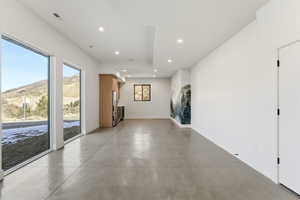 Hall featuring finished concrete floors, a mountain view, and recessed lighting