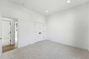 Unfurnished bedroom featuring carpet, recessed lighting, and a closet