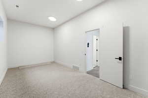Spare room with light colored carpet and baseboards