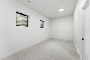 Empty room with light carpet and baseboards