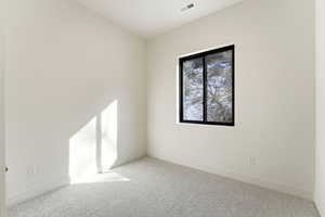 Empty room featuring carpet and baseboards