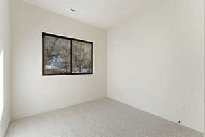 Carpeted empty room with baseboards