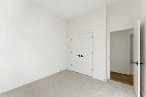 Unfurnished bedroom with carpet flooring and a closet