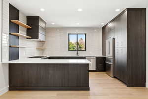 Kitchen with open shelves, a peninsula, modern cabinets, stainless steel appliances, and light wood-style flooring