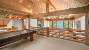 Game room with ceiling fan, a wood ceiling with exposed beams, billiards, carpet floors, and rustic walls