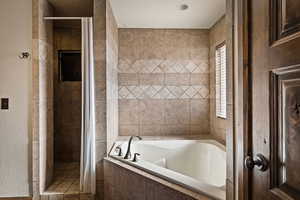 Master Full bathroom with a garden tub, a shower stall, and a textured wall