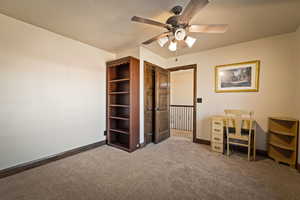 Upstairs bedroom carpet and a ceiling fan