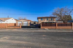 View of front of home featuring a fenced front yard, an outbuilding, and a residential view