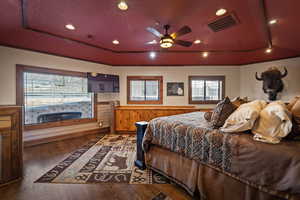Guest Bedroom Suite featuring a textured ceiling, hardwood / wood-style floors, ceiling fan, recessed lighting, and a tray ceiling