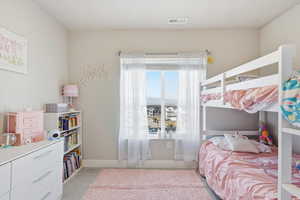 Bedroom featuring light carpet and baseboards