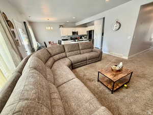 Living room with a chandelier, recessed lighting, and light colored carpet