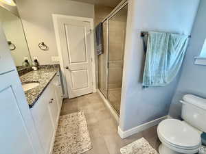 Full bathroom with vanity, a stall shower, and light tile patterned floors