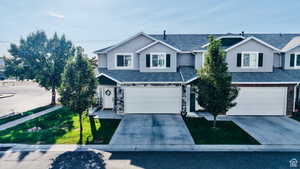 Traditional home with concrete driveway, stucco siding, and a shingled roof