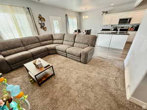 Living area featuring a chandelier, light carpet, and recessed lighting