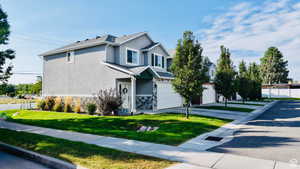 View of front of property featuring stucco siding, stone siding, a garage, and driveway