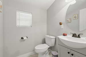 Half bathroom featuring toilet and vanity