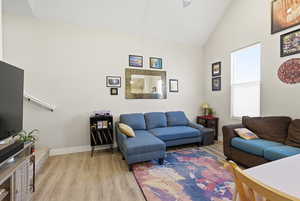 Living room with LVP flooring and vaulted ceiling