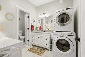 Bathroom and Laundry room featuring light tile finish flooring and stacked washer / drying machine