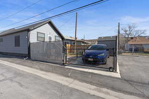 View of back of home featuring a fenced yard and a gate
