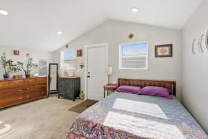 Bedroom with lofted ceiling, multiple windows, light carpet, and recessed lighting