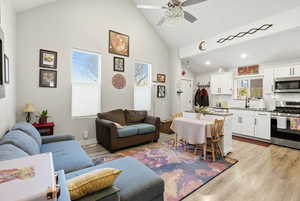 Living area featuring high vaulted ceiling, LVP flooring, and a ceiling fan