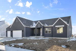 View of front facade featuring stucco siding, an attached garage, and driveway