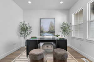 Office space featuring wood finished floors and recessed lighting