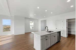 Kitchen with an island with sink, recessed lighting, open floor plan, dark wood finished floors, and stainless steel dishwasher