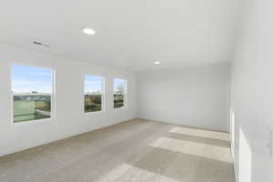 Spare room featuring light colored carpet and recessed lighting