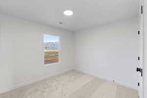 Carpeted spare room with baseboards