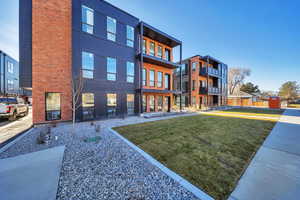 Rear view of property with a lawn and brick siding