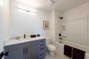 Bathroom with vanity, shower / bathtub combination, and light tile patterned flooring