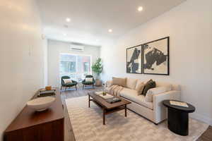 Living room with light wood finished floors and recessed lighting