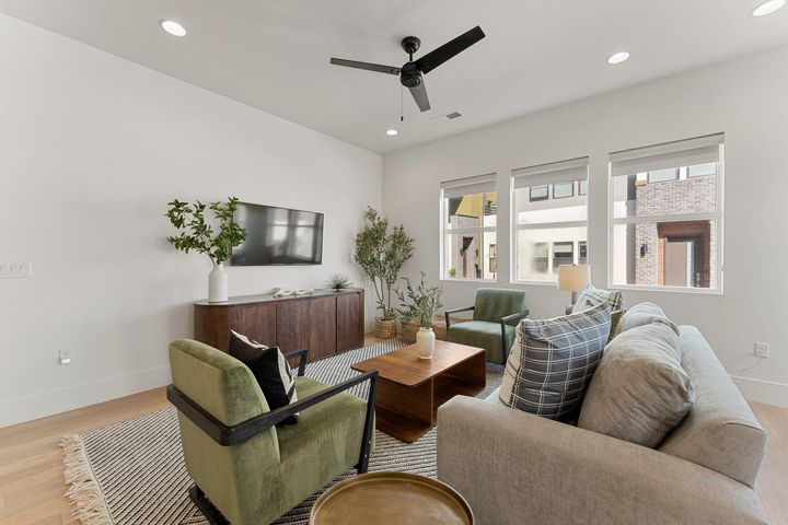 Living area with light wood finished floors, recessed lighting, and ceiling fan
