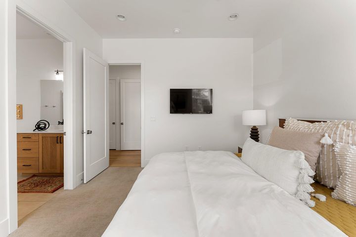 Bedroom featuring light carpet and connected bathroom