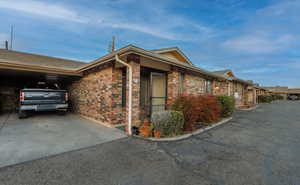 View of front of house with brick siding and an attached carport