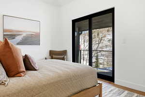 Bedroom with wood finished floors and baseboards
