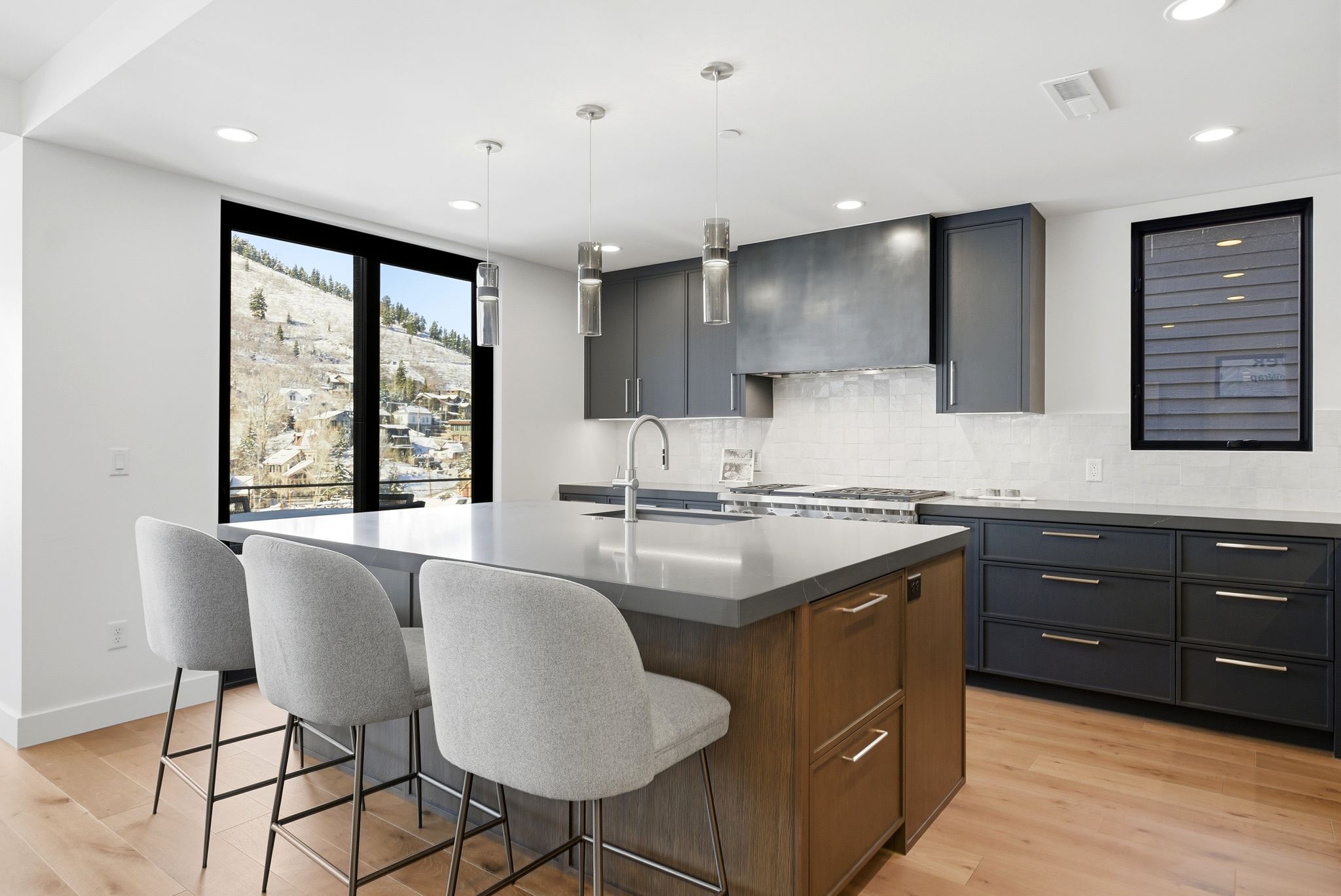 Kitchen with pendant lighting, light wood-type flooring, a center island with sink, a breakfast bar, and recessed lighting