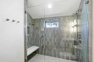 Full bathroom featuring a stall shower and vaulted ceiling