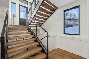 Staircase featuring wood finished floors and baseboards