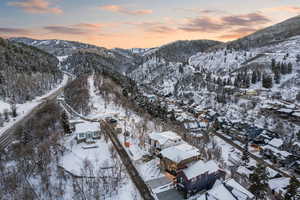 Snowy aerial view featuring a mountain view and a residential view