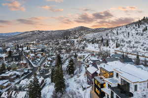 Snowy aerial view featuring a mountain view and a residential view