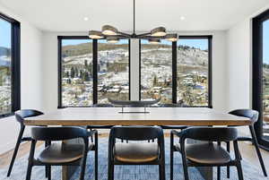 Dining space with light wood finished floors, a mountain view, and a chandelier