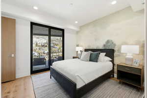 Bedroom with access to exterior, light wood finished floors, and recessed lighting