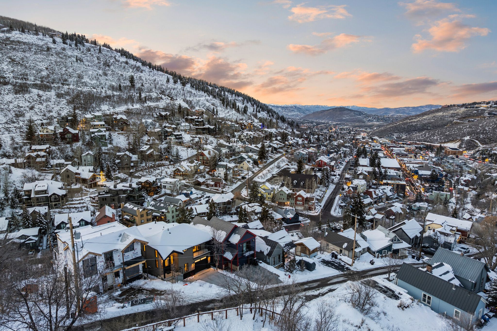 Snowy aerial view featuring a mountain view and a residential view