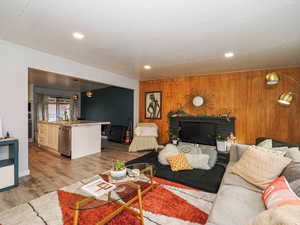 Living area featuring light wood-type flooring and wooden walls