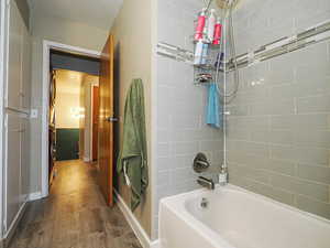 Full bath featuring shower / bathtub combination and dark wood-style floors