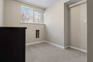 Empty room with light carpet and baseboards