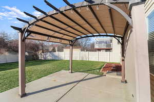 Fenced backyard featuring a pergola and a patio area