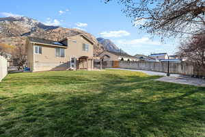Rear view of house featuring a fenced backyard and a mountain view